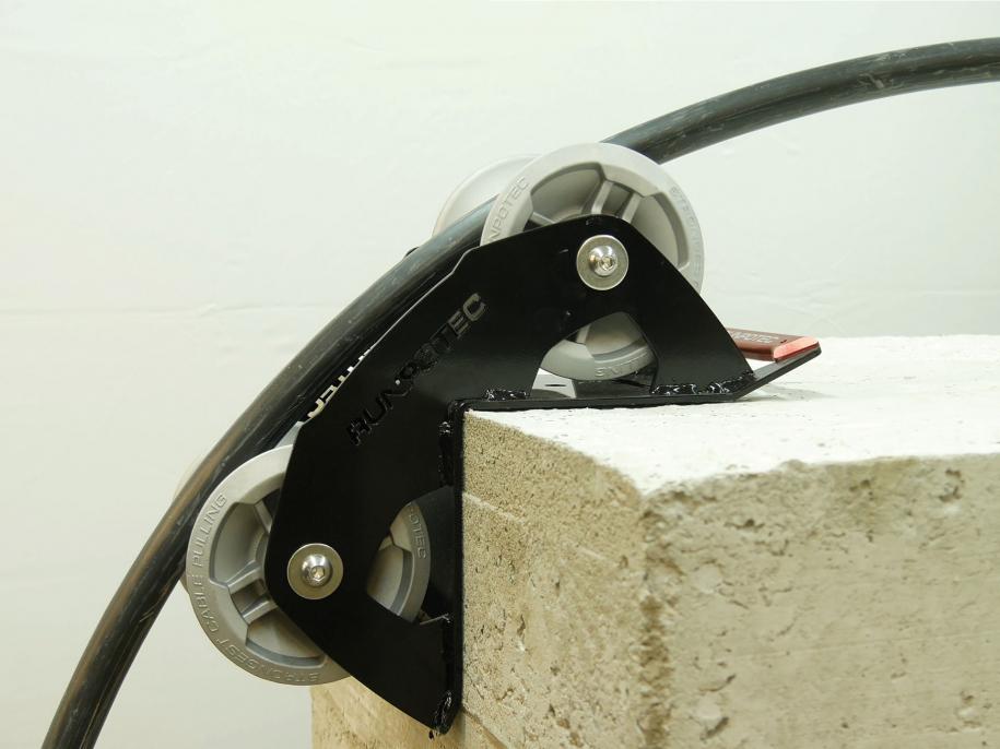 The cable guide roller - 90 degrees is ideally suited for use on various edges to pull cables gently around corners with the least possible resistance. Example photo of roller attached to the corner of a concrete block